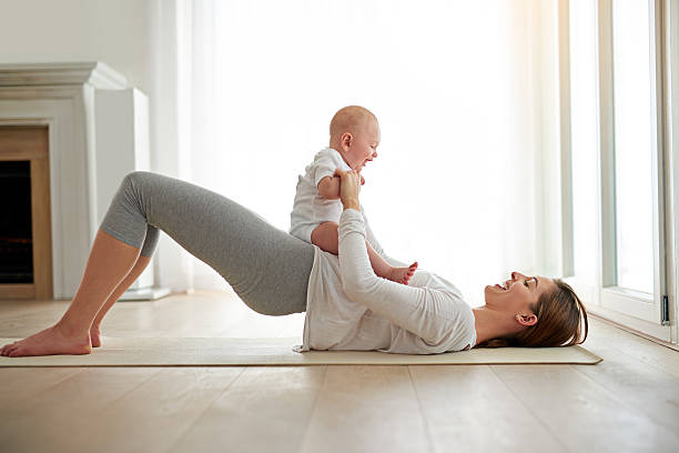 Mother doing postnatal fitness exercise with baby at Herburn Studio ladies-only fitness centre in Anchalummood, Kollam