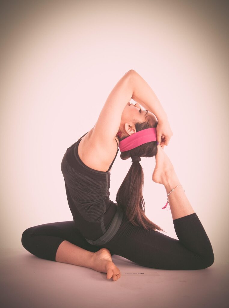 Woman performing advanced yoga backbend pose to improve flexibility at Herburn Studio