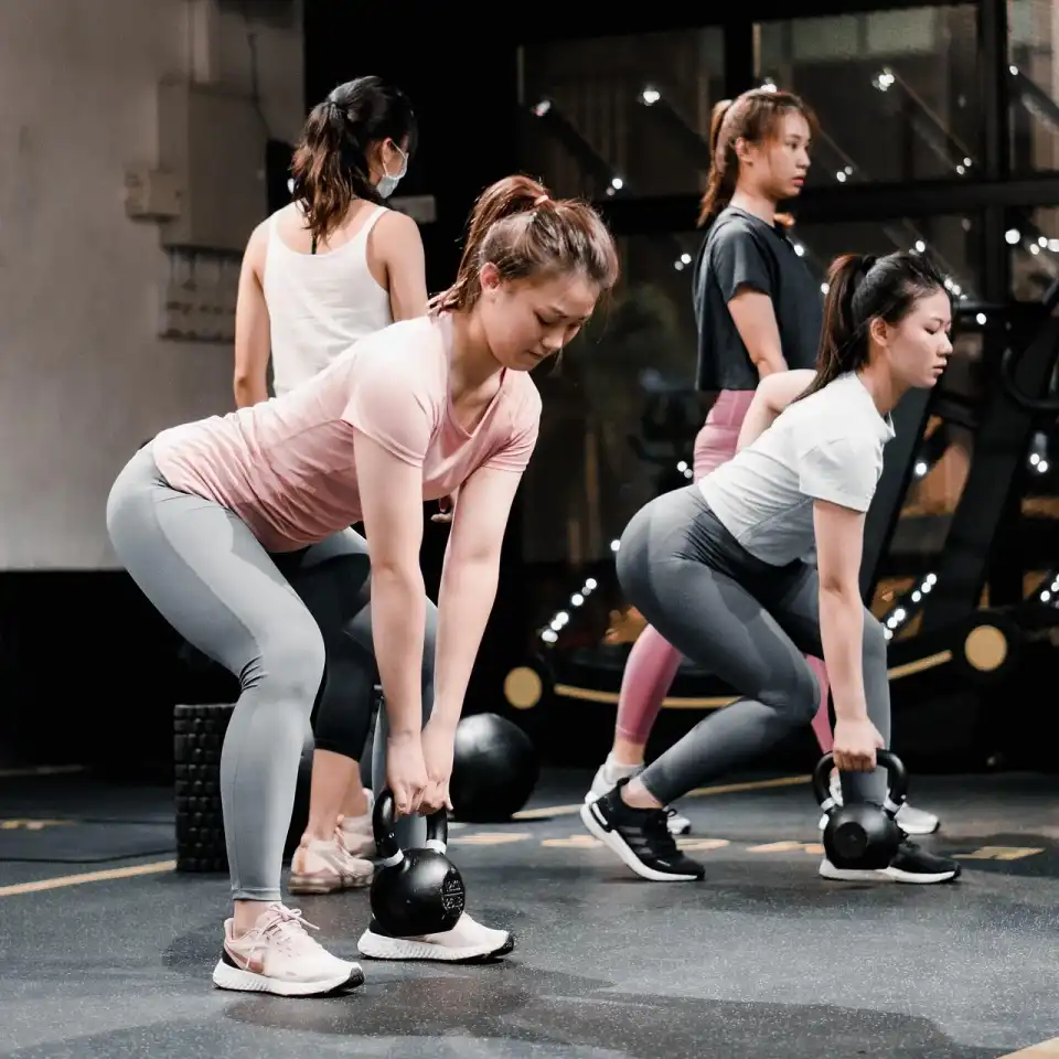 Group of women performing kettlebell deadlifts during a strength training session at Herburn Studio